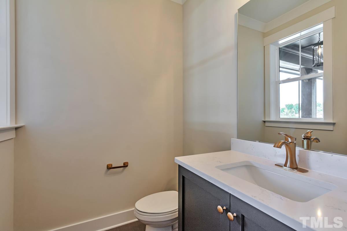 6409 Camellia Creek Drive Raleigh, NC 27603 - Photo 30 of 30 a bathroom with a granite countertop sink a toilet and a mirror