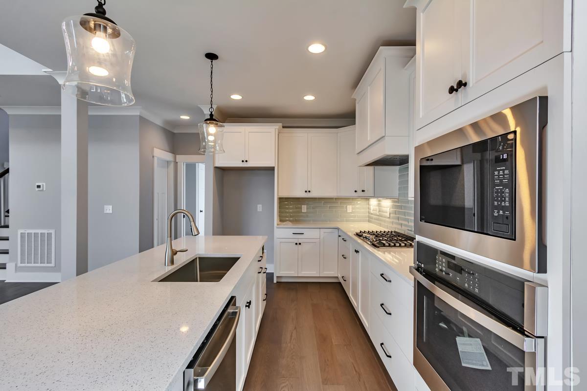 6409 Camellia Creek Drive Raleigh, NC 27603 - Photo 10 of 30 a large kitchen with stainless steel appliances kitchen island a large counter space a sink and cabinets