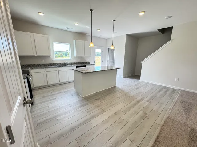 a kitchen with granite countertop a sink and a stove top oven