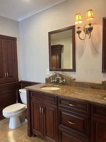 a bathroom with a toilet a sink and mirror