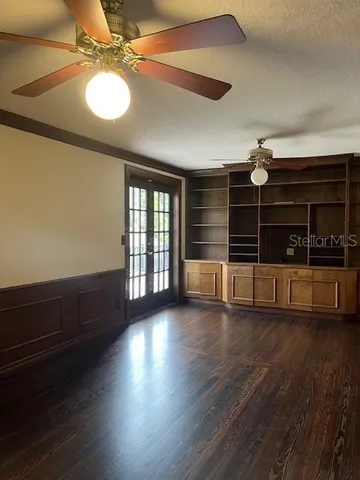 a view of a livingroom with wooden floor and a ceiling fan