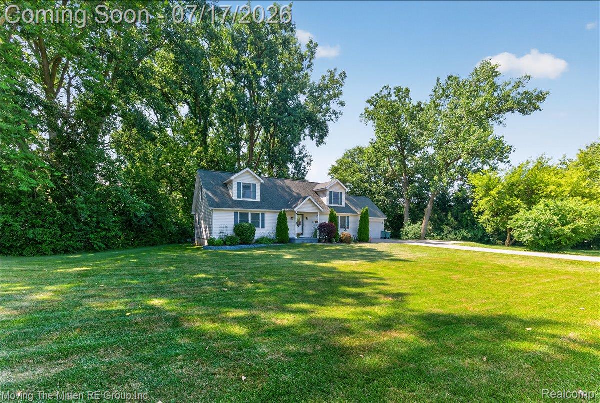 40162 Alden Road Belleville, MI 48111 - Photo 2 of 67 Light-colored facade with dormer windows, surrounded by mature trees