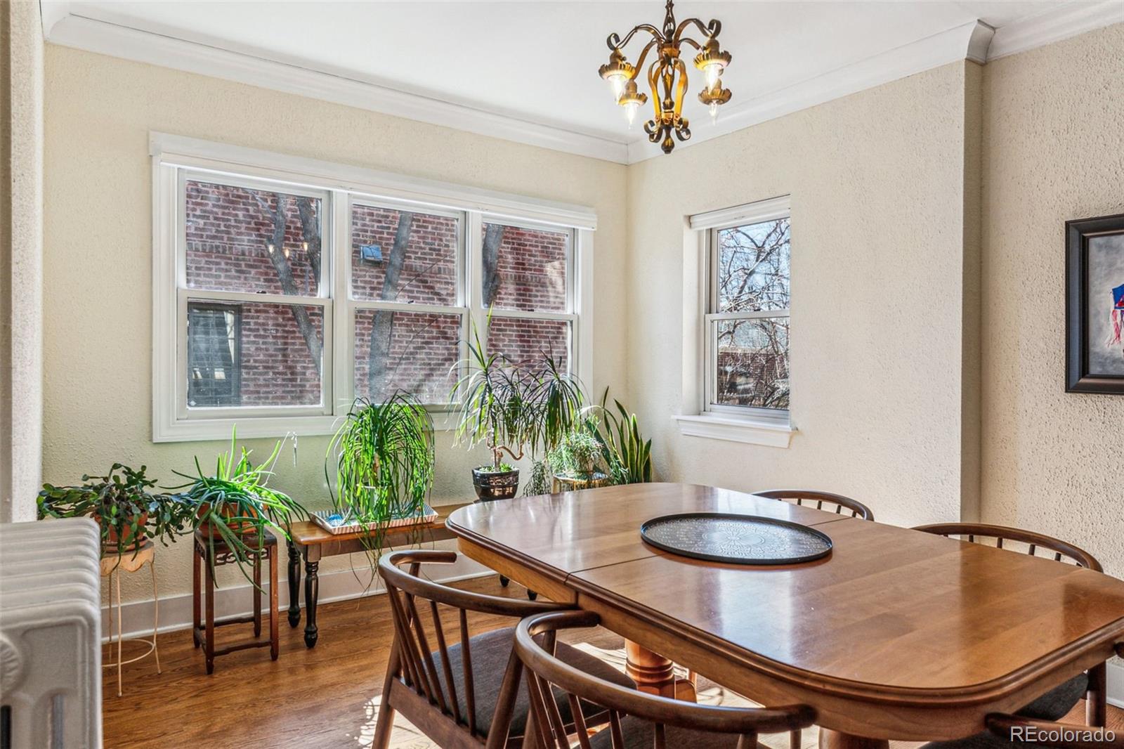 1965 Jasmine Street Denver, CO 80220 - Photo 11 of 41 a dining room with furniture a potted plant and wooden floor