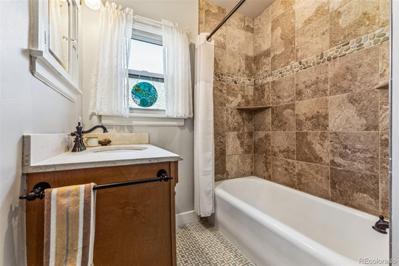 1965 Jasmine Street Denver, CO 80220 - Photo 28 of 41 a bathroom with a sink a bathtub and a window
