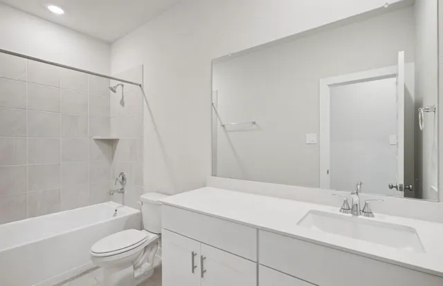 a bathroom with a granite countertop sink a toilet and shower