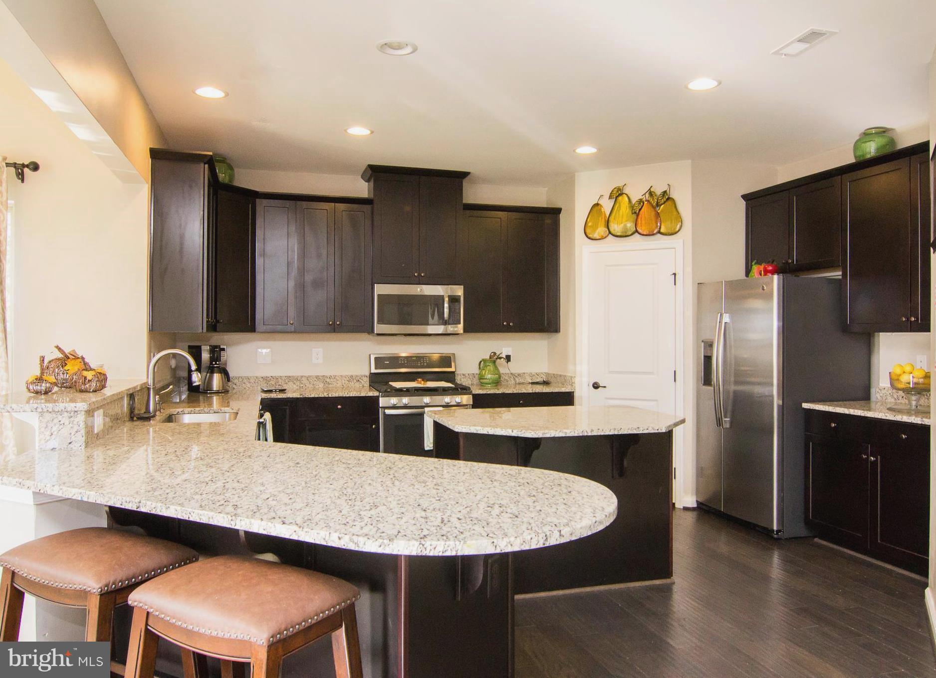 10422 Windlass Run Road Baltimore, MD 21220 - Photo 5 of 30 a kitchen with stainless steel appliances granite countertop a sink a microwave a refrigerator and chairs