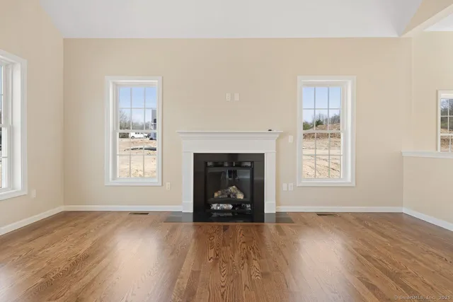 an empty room with wooden floor and a window