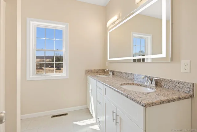 a bathroom with a granite countertop sink and a mirror