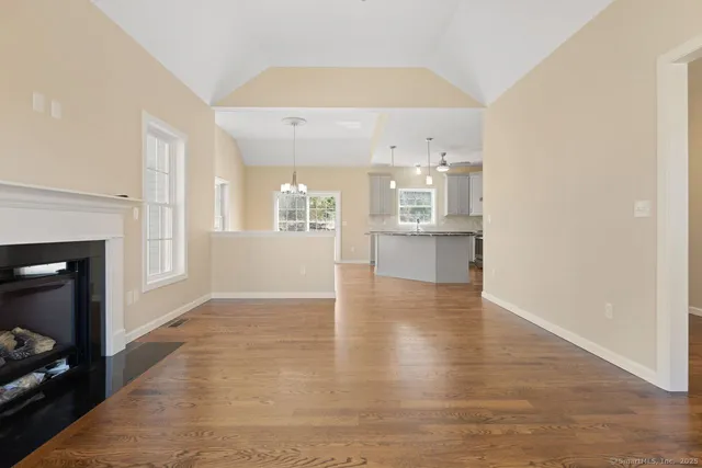 a view of a kitchen with wooden floor and a fireplace