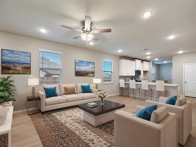 a living room with furniture and a view of kitchen