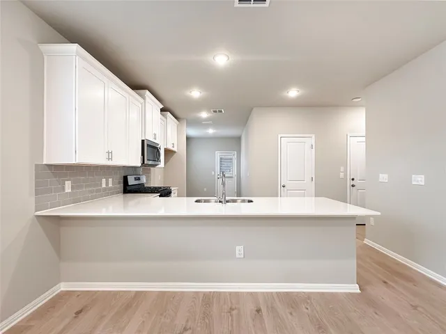 a kitchen with kitchen island a sink and a stove top oven