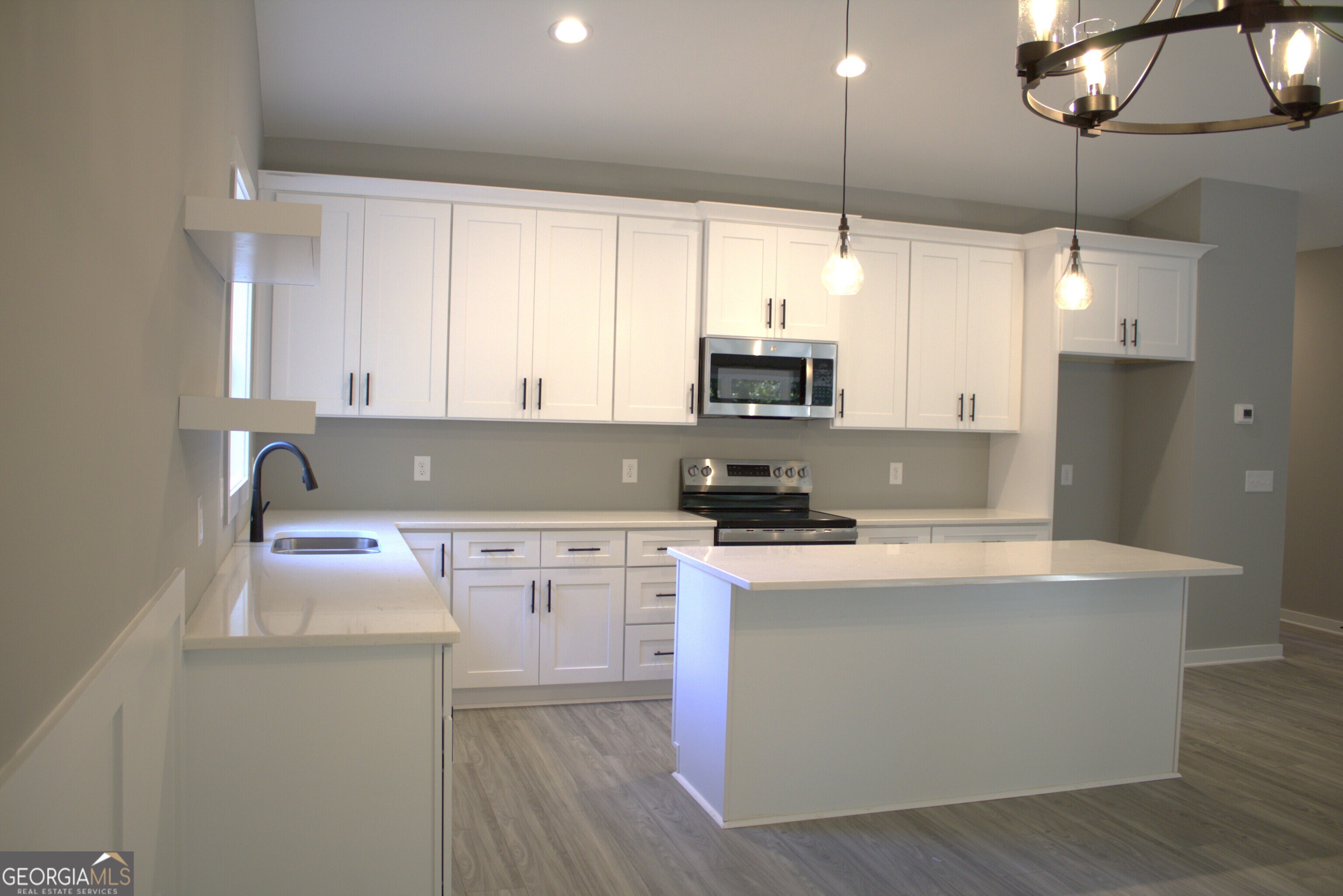 247 North Point Circle Hartwell, GA 30643 - Photo 5 of 18 a kitchen with kitchen island a white counter top space cabinets and appliances