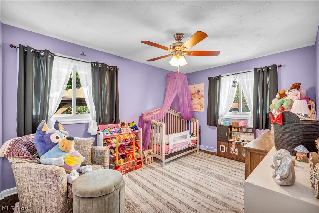 977 Lloyd Road Wickliffe, OH 44092 - Photo 14 of 38 Lavender-painted walls, a ceiling fan with light fixture, and wood-finish flooring