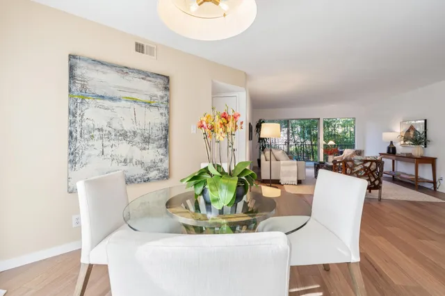 a dining room with furniture potted plants and wooden floor