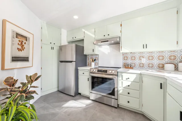 a kitchen with stainless steel appliances a stove a refrigerator and cabinets