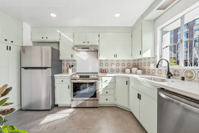 a kitchen with stainless steel appliances a refrigerator sink and cabinets