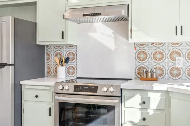 a stove top oven sitting inside of a kitchen