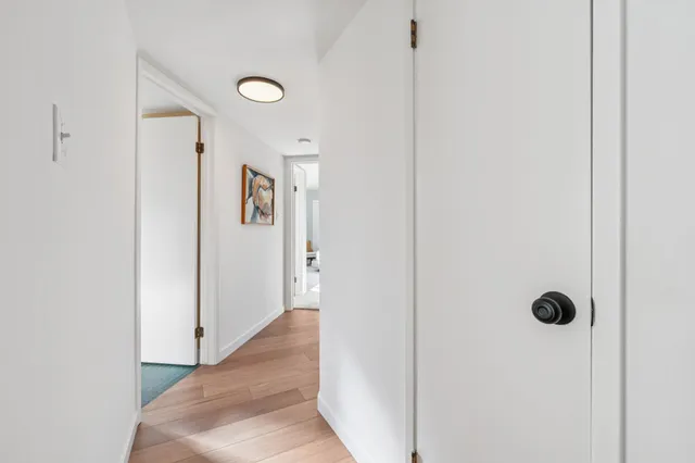 a spacious bedroom with a bed and a lamp on table