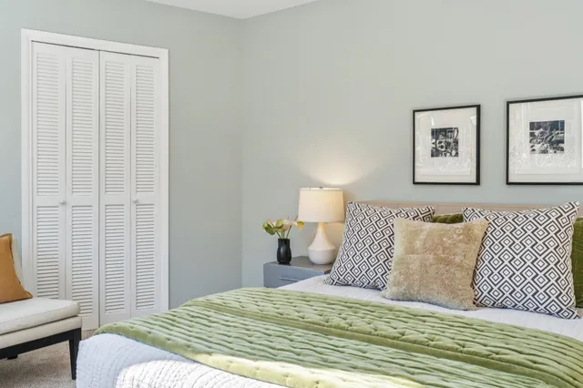 a bedroom with a bed and a painting on the wall