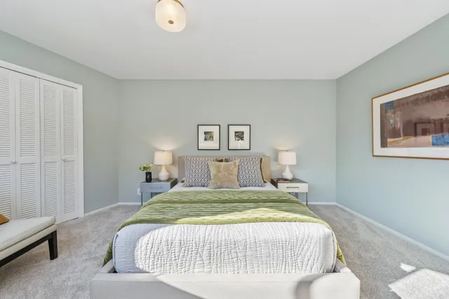 a bedroom with a bed and painting on the wall