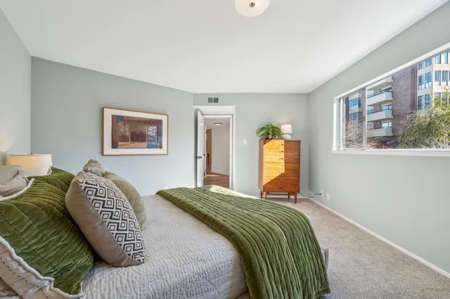 a bedroom with a bed and painting on the wall