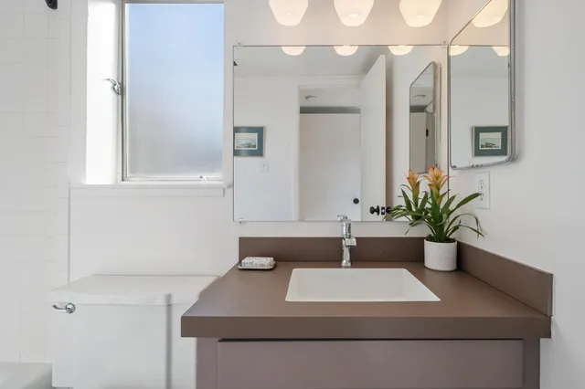 a bathroom with a toilet sink and mirror