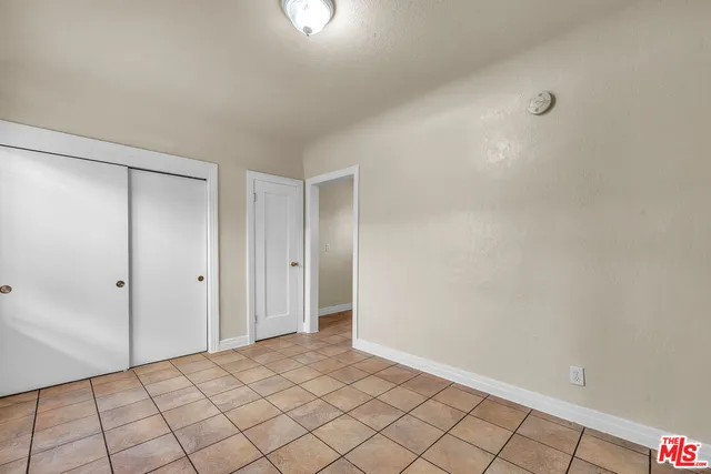 a view of a backyard with a tree and wooden fence