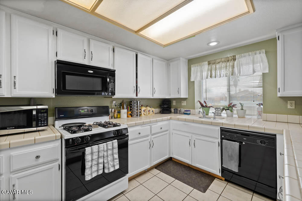 2425 Williams Court Rosamond, CA 93560 - Photo 14 of 35 a kitchen with granite countertop white cabinets and white appliances