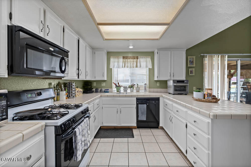2425 Williams Court Rosamond, CA 93560 - Photo 18 of 35 a kitchen with stainless steel appliances granite countertop a stove a sink and a microwave