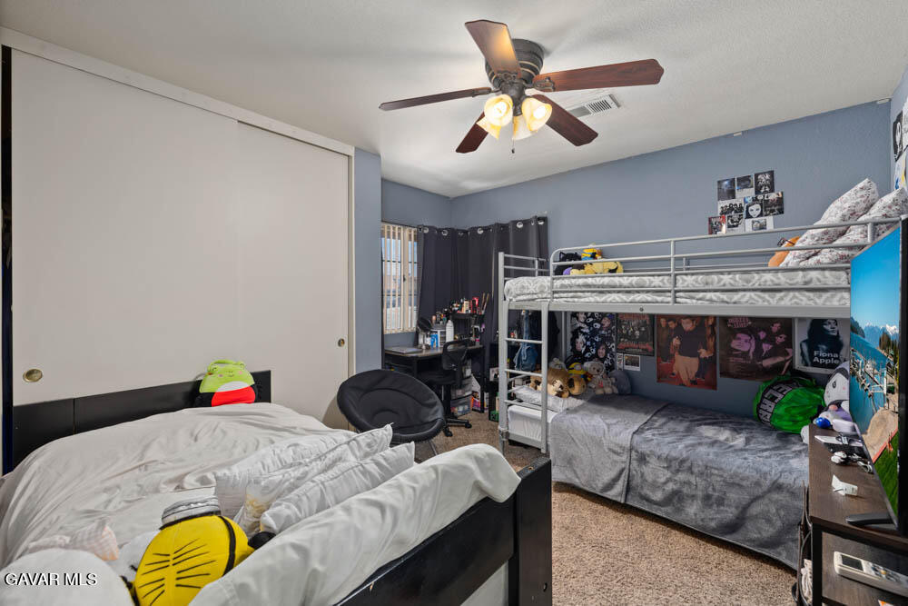 2425 Williams Court Rosamond, CA 93560 - Photo 20 of 35 a bedroom with a bed a couch and a potted plant