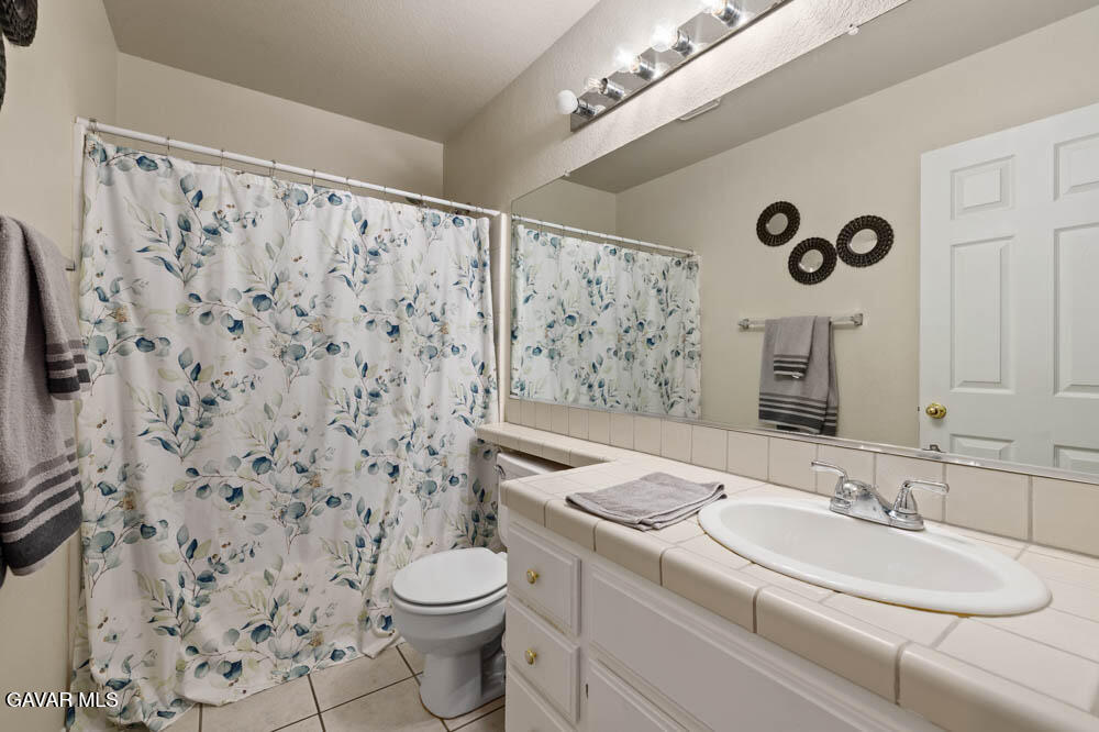 2425 Williams Court Rosamond, CA 93560 - Photo 22 of 35 a bathroom with a sink a toilet and shower curtain
