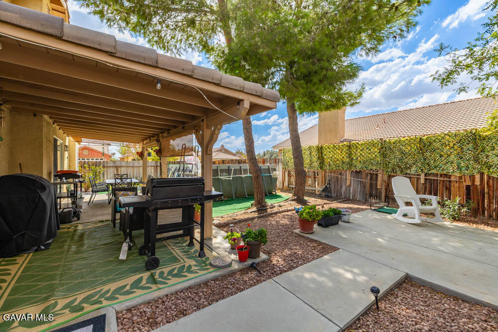 2425 Williams Court Rosamond, CA 93560 - Photo 28 of 35 a view of a patio with table and chairs potted plants with wooden floor and fence