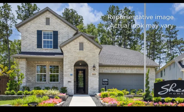 a front view of a house with a yard and garden