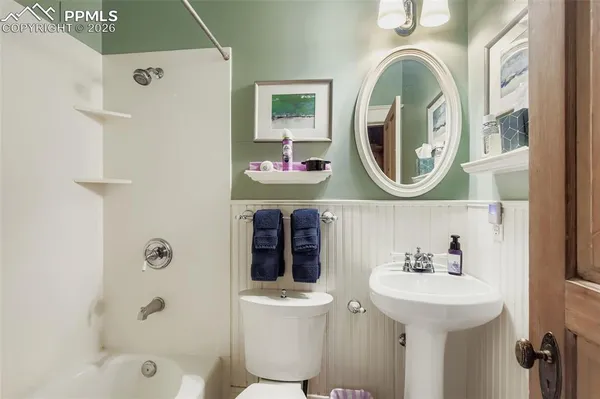 a bathroom with a sink a toilet and shower curtain