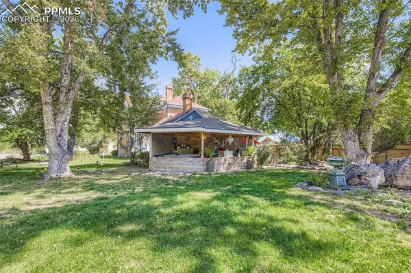 a view of a house with a tree and wooden fence