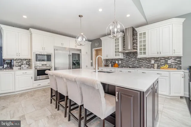 a kitchen with kitchen island a sink and a stove with cabinets