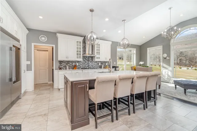 a kitchen with granite countertop white cabinets and window