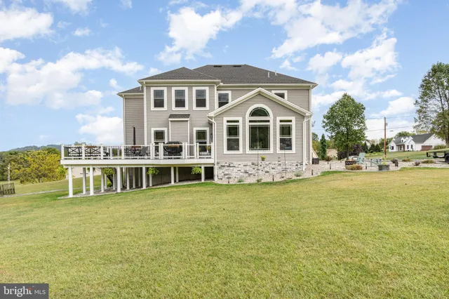 front view of a brick house with a large window and potted plants