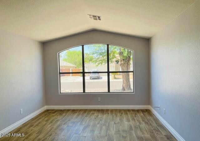 12817 West Alvarado Road Avondale, AZ 85392 - Photo 4 of 15 an empty room with wooden floor and windows