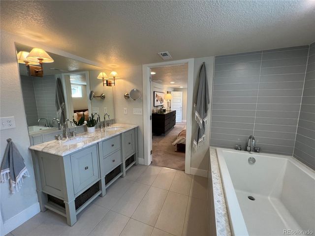 a bathroom with a double vanity sink a mirror and a bathtub