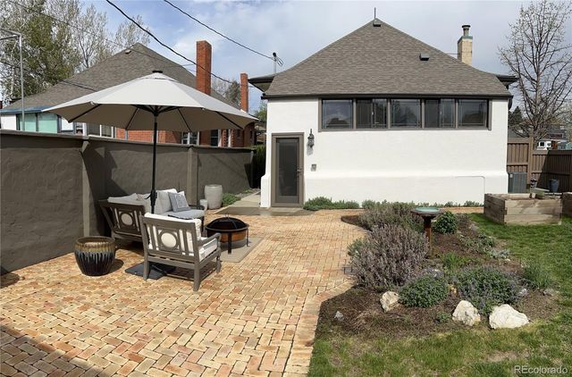 a roof deck with table and chairs under an umbrella