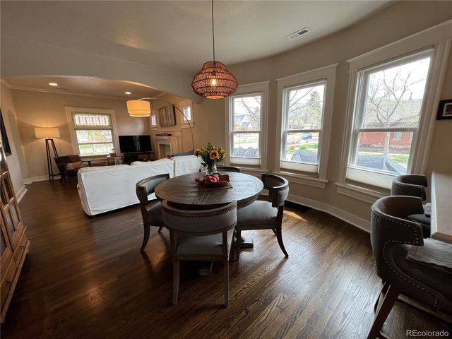 a view of a dining room with furniture a chandelier and wooden floor