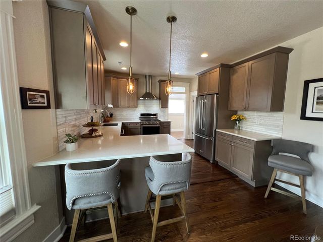 a kitchen with a refrigerator a sink and chairs