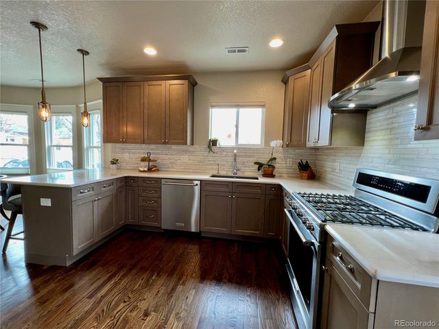 a kitchen with a sink a window a counter and stainless steel appliances