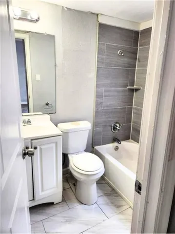 a white toilet sitting next to a bathroom sink