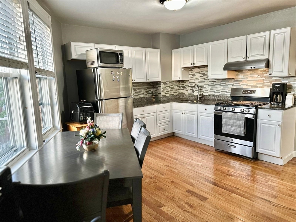 a kitchen with stainless steel appliances granite countertop a sink a stove and refrigerator