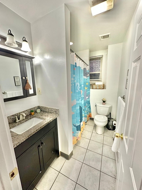 139 Park Street, Unit 4 Chelsea, MA 02150 - Photo 11 of 11 a bathroom with a sink toilet and mirror