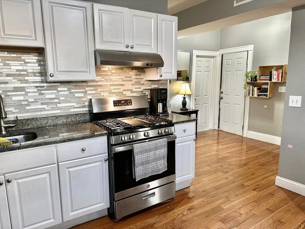 139 Park Street, Unit 4 Chelsea, MA 02150 - Photo 2 of 11 a kitchen with stainless steel appliances granite countertop a stove a refrigerator and a white cabinets