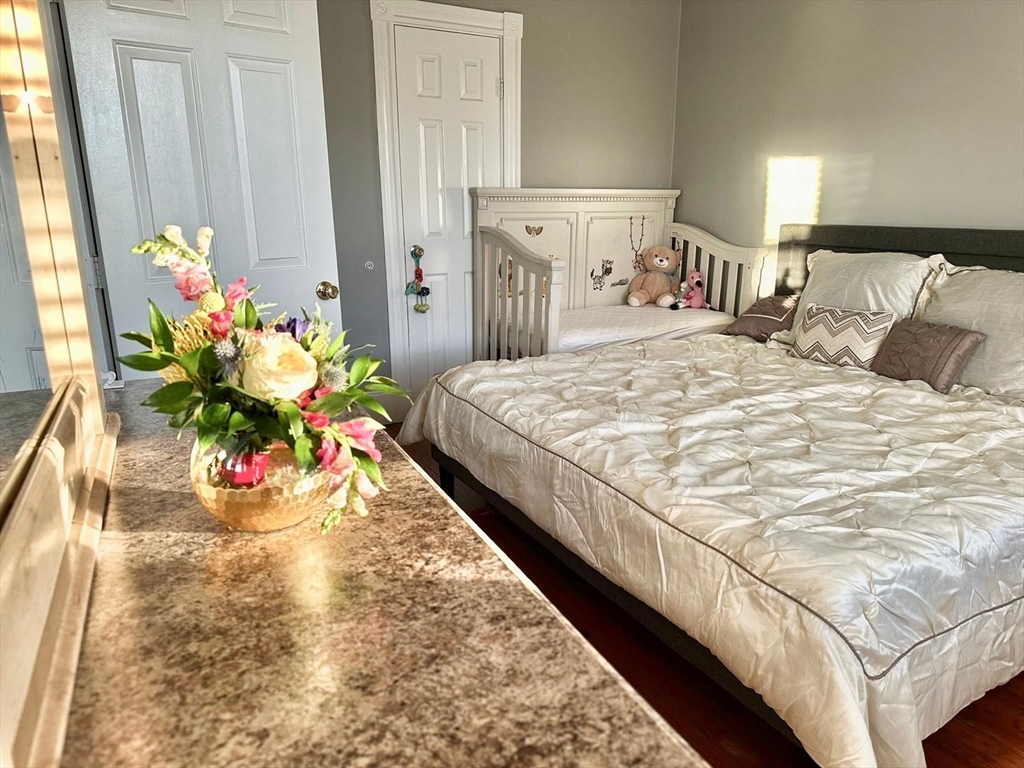 139 Park Street, Unit 4 Chelsea, MA 02150 - Photo 5 of 11 a bedroom with bed and flowers
