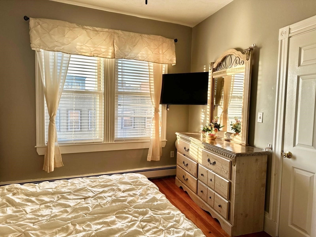 139 Park Street, Unit 4 Chelsea, MA 02150 - Photo 7 of 11 a bedroom with a bed and a flat tv screen on dresser